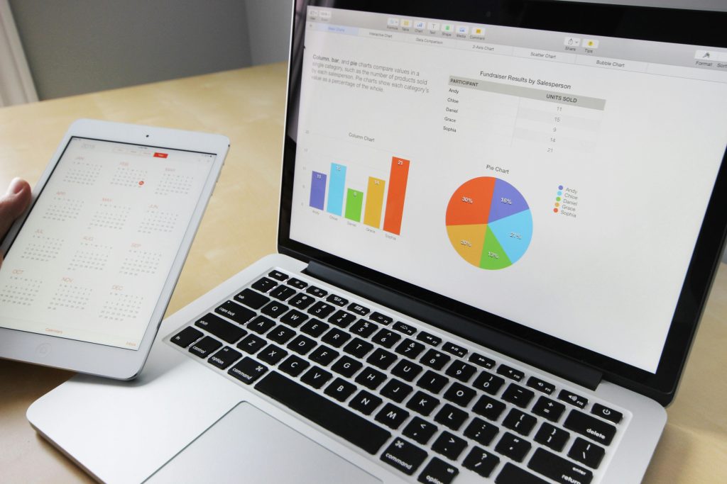 pexels photo 265087 265087 Laptop displaying charts and graphs with tablet calendar for data analysis and planning.